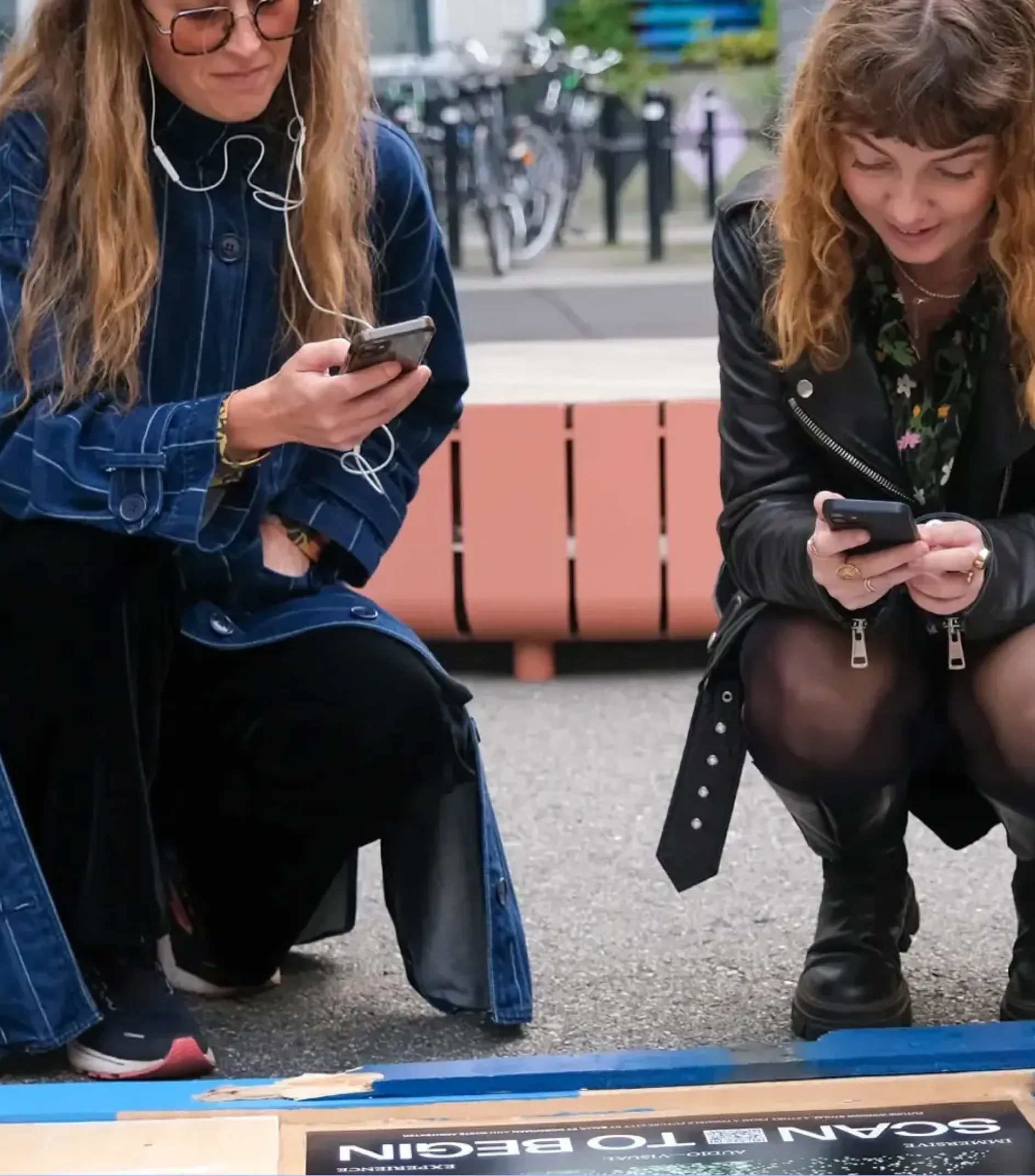 Two women scanning a QR code on the ground