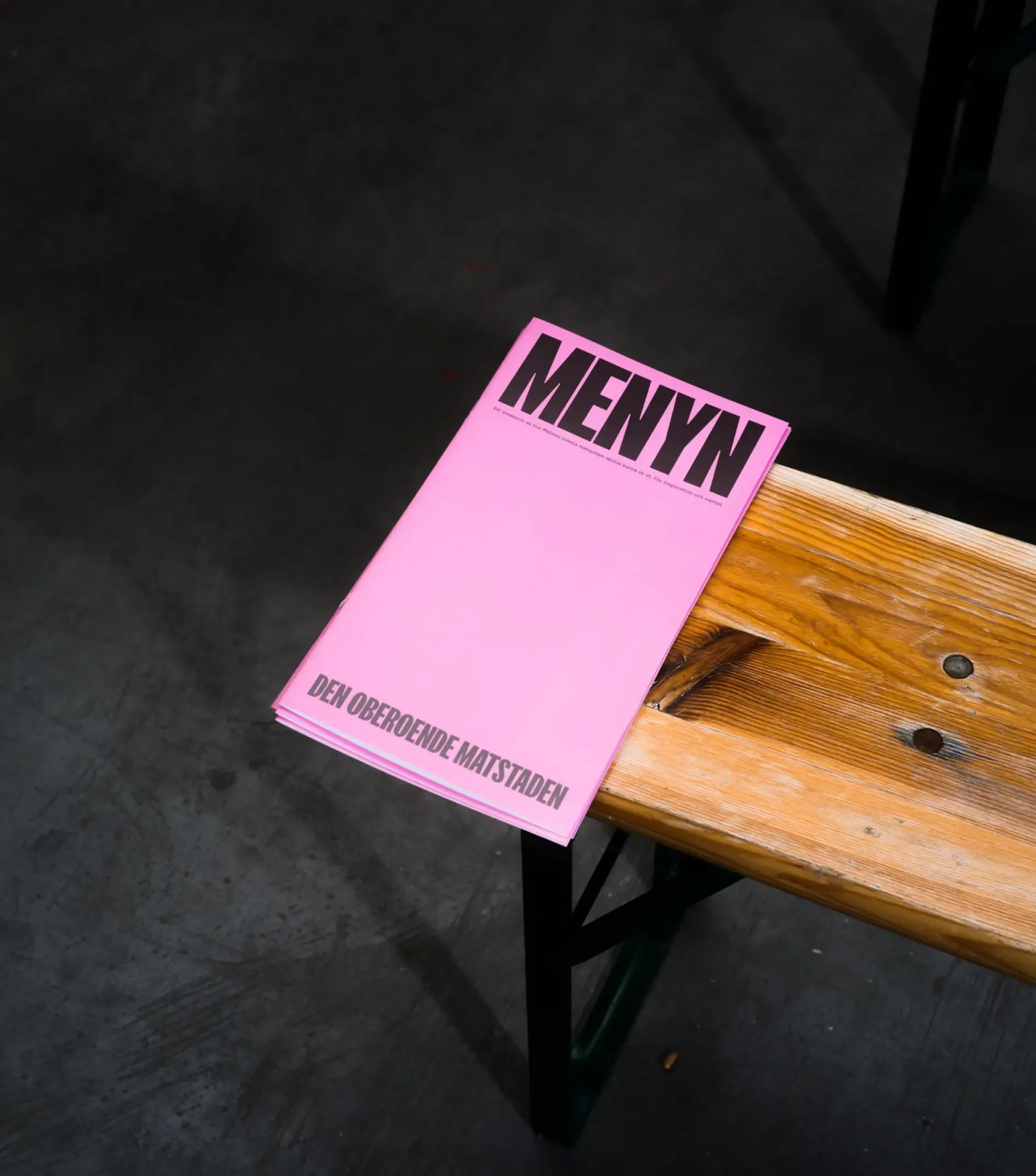 A bench with a pink menu on it