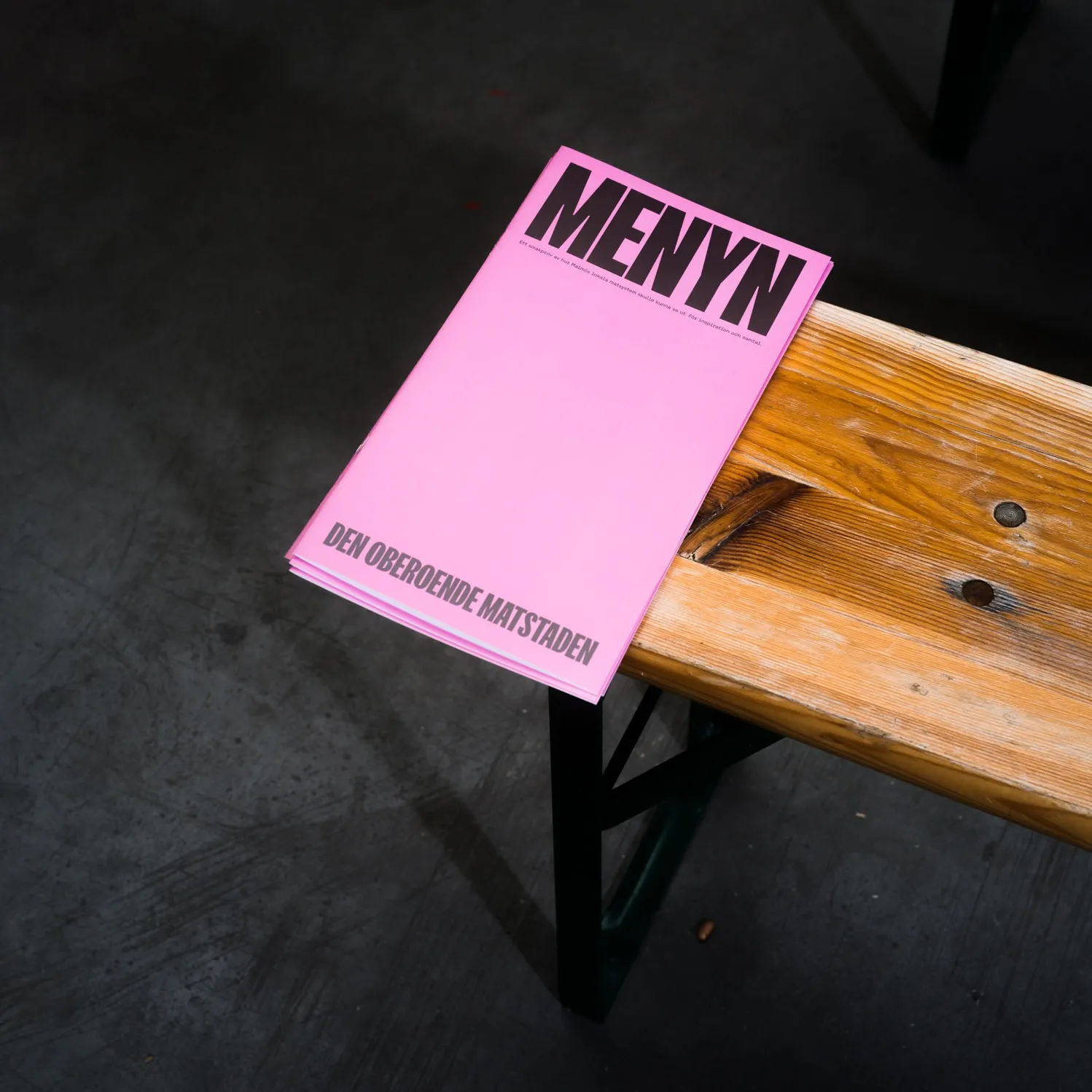 A paper menu lying on a bench