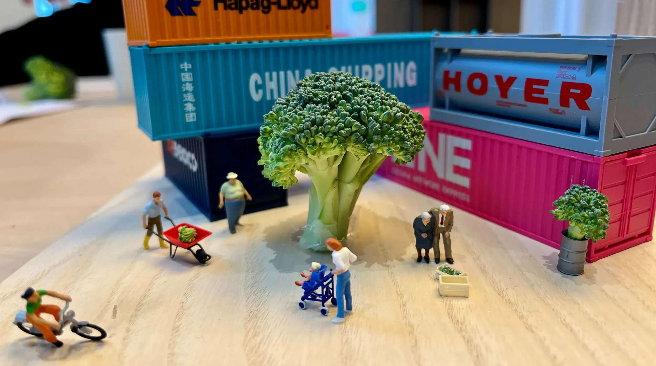 Miniature people in around a brocolli tree